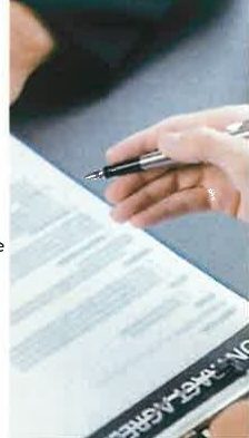 A hand signing an investment contract